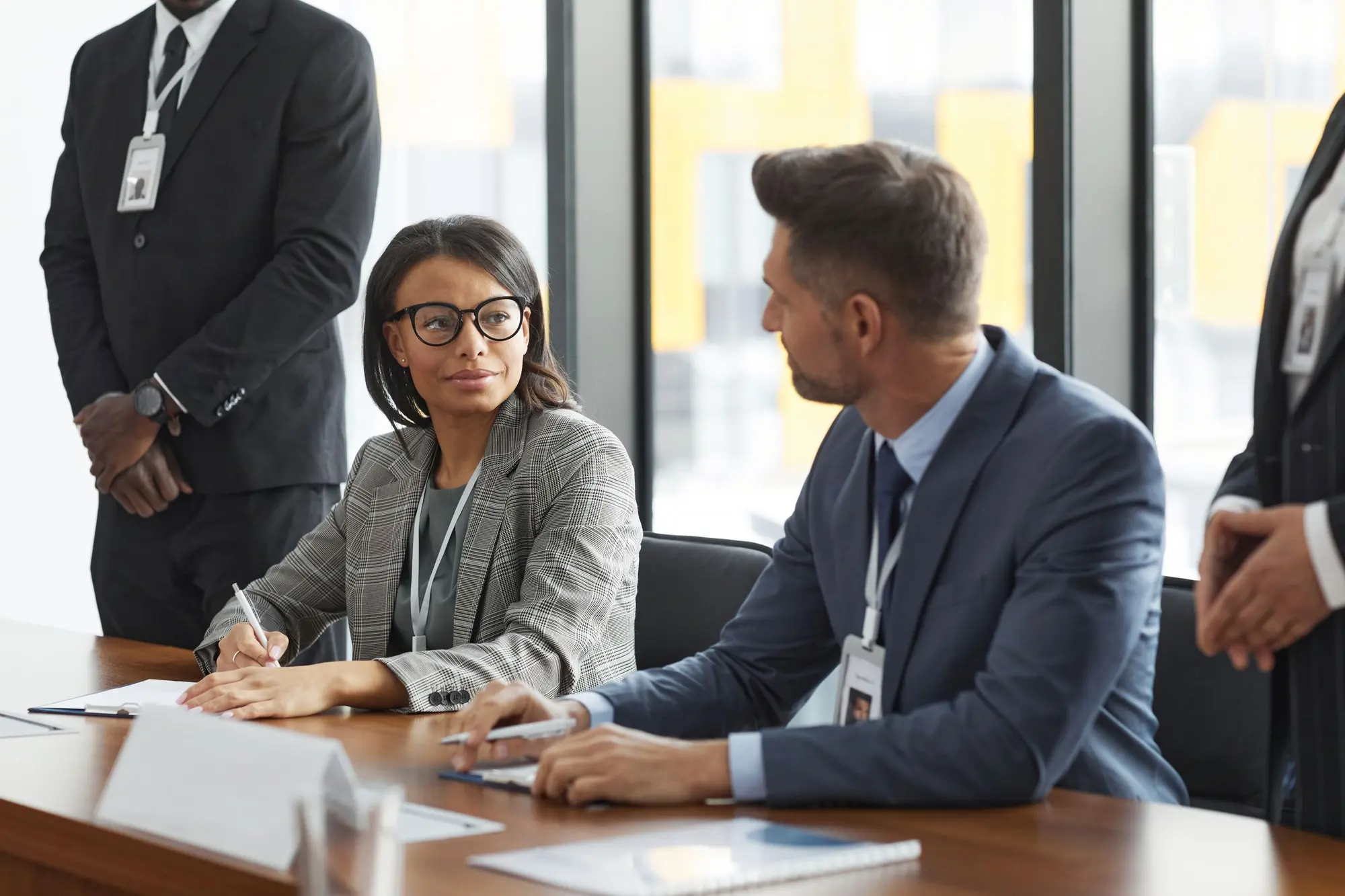 Delegates with name badges in discussion at a boardroom table