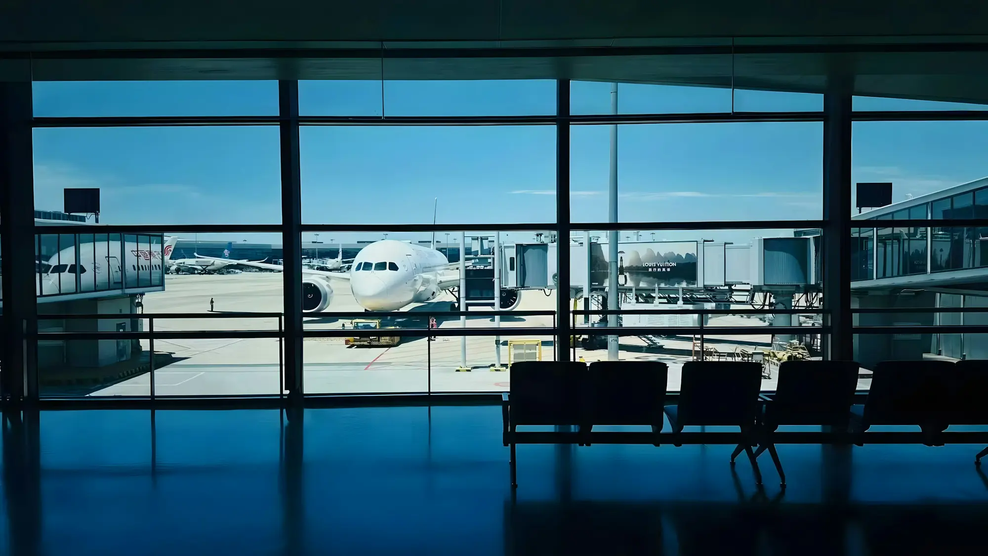 An aircraft at the gate, seen through a terminal window